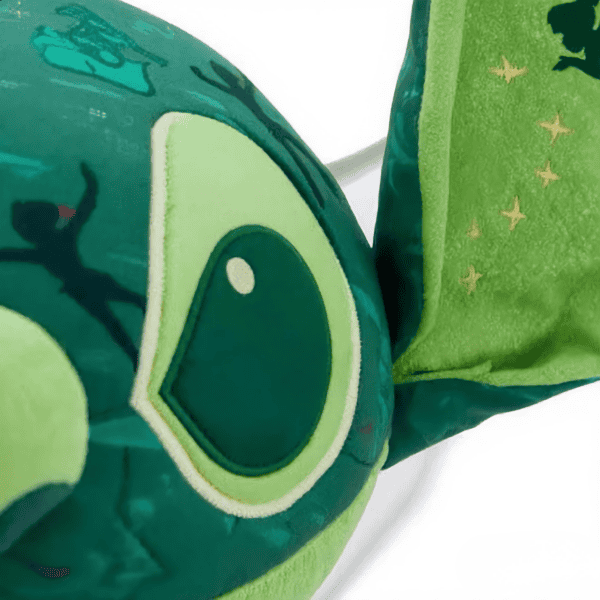 Gedetailleerde close-up van het gezicht van een Stitch pluche knuffel in Peter Pan-thema.