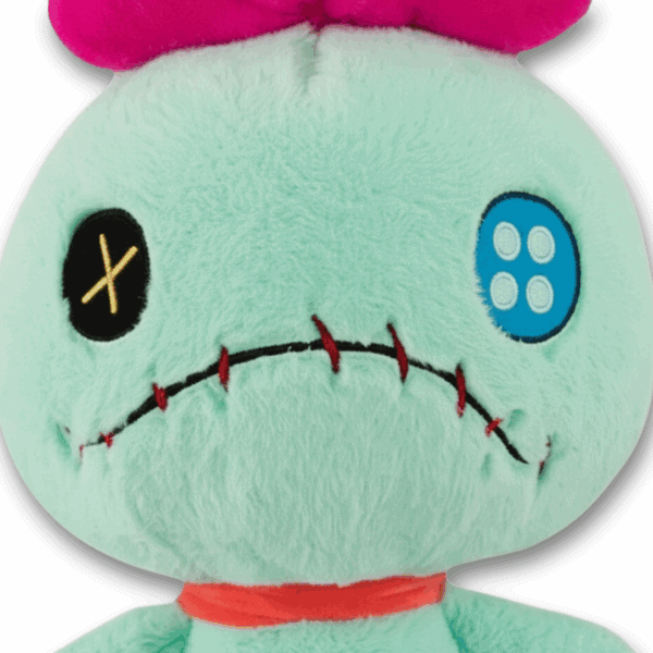 Close-up van Scrump knuffel, met focus op het gezicht, grote knoopogen en opvallende stiksels.